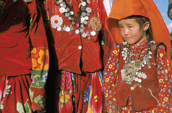 Kirghiz women in the Afghan Pamirs wear their finery, including necklaces of silver coins, at a wedding.: Photograph from Tibet Wild by George B. Schaller. Reproduced by permission of Island Press.